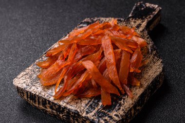 Kurutulmuş hindi eti, tuzlu ve baharatlı koyu beton arka planda.