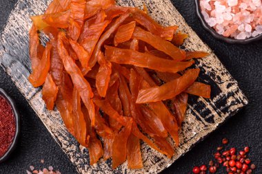 Kurutulmuş hindi eti, tuzlu ve baharatlı koyu beton arka planda.