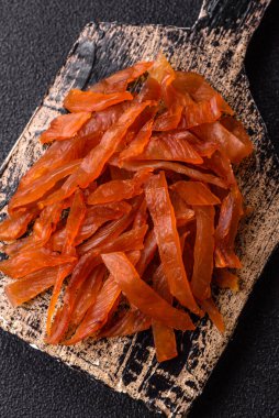 Kurutulmuş hindi eti, tuzlu ve baharatlı koyu beton arka planda.