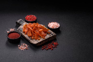 Kurutulmuş hindi eti, tuzlu ve baharatlı koyu beton arka planda.