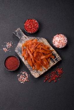 Kurutulmuş hindi eti, tuzlu ve baharatlı koyu beton arka planda.