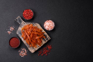 Kurutulmuş hindi eti, tuzlu ve baharatlı koyu beton arka planda.