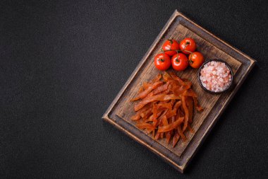 Kurutulmuş hindi eti, tuzlu ve baharatlı koyu beton arka planda.