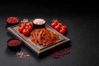 Kurutulmuş hindi eti, tuzlu ve baharatlı koyu beton arka planda.