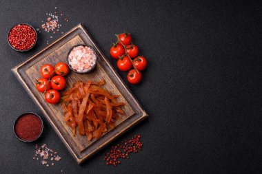 Kurutulmuş hindi eti, tuzlu ve baharatlı koyu beton arka planda.