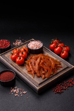 Kurutulmuş hindi eti, tuzlu ve baharatlı koyu beton arka planda.