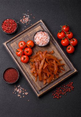 Kurutulmuş hindi eti, tuzlu ve baharatlı koyu beton arka planda.