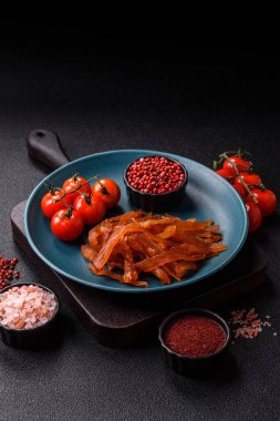 Kurutulmuş hindi eti, tuzlu ve baharatlı koyu beton arka planda.