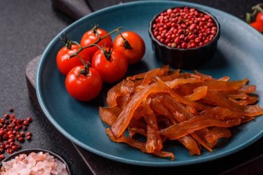 Kurutulmuş hindi eti, tuzlu ve baharatlı koyu beton arka planda.
