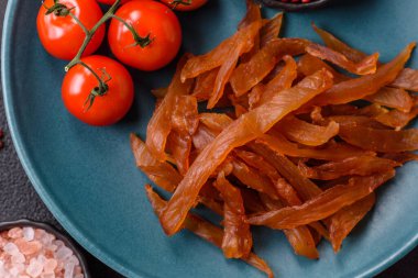 Kurutulmuş hindi eti, tuzlu ve baharatlı koyu beton arka planda.