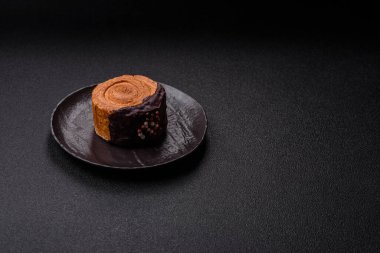 Yuvarlak, tatlı New York rulo kruvasan. Koyu beton arka planda çikolata kremalı.