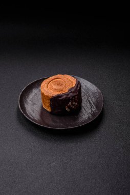 Yuvarlak, tatlı New York rulo kruvasan. Koyu beton arka planda çikolata kremalı.