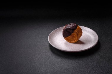 Yuvarlak, tatlı New York rulo kruvasan. Koyu beton arka planda çikolata kremalı.