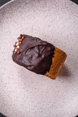 Yuvarlak, tatlı New York rulo kruvasan. Koyu beton arka planda çikolata kremalı.