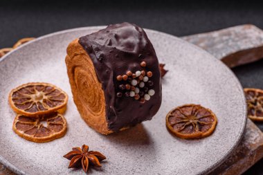 Yuvarlak, tatlı New York rulo kruvasan. Koyu beton arka planda çikolata kremalı.