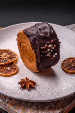 Yuvarlak, tatlı New York rulo kruvasan. Koyu beton arka planda çikolata kremalı.