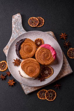 Yuvarlak, tatlı New York rulo kruvasanı. Koyu beton bir arka planda krema var.