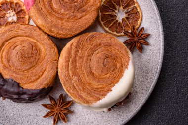 Yuvarlak, tatlı New York rulo kruvasanı. Koyu beton bir arka planda krema var.