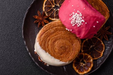 Yuvarlak, tatlı New York rulo kruvasanı. Koyu beton bir arka planda krema var.