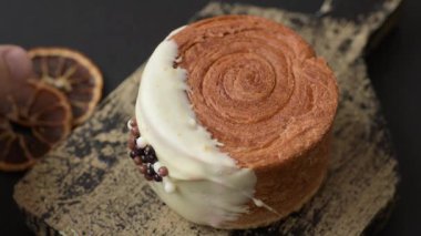 Yuvarlak, tatlı New York rulo kruvasanı. Koyu beton bir arka planda krema var.