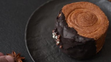 Yuvarlak, tatlı New York rulo kruvasanı. Koyu beton bir arka planda krema var.