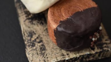 Yuvarlak, tatlı New York rulo kruvasanı. Koyu beton bir arka planda krema var.