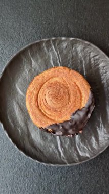 Yuvarlak, tatlı New York rulo kruvasanı. Koyu beton bir arka planda krema var.