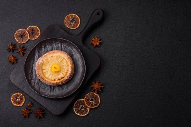 Koyu beton arka planda ananaslı yuvarlak turta.