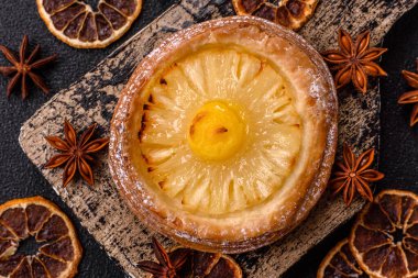 Koyu beton arka planda ananaslı yuvarlak turta.