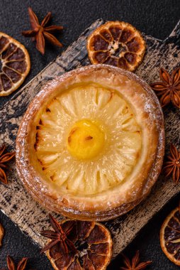 Koyu beton arka planda ananaslı yuvarlak turta.