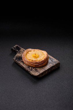 Koyu beton arka planda ananaslı yuvarlak turta.