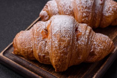 Koyu beton arka planda meyveli taze kruvasan.