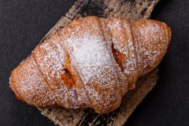 Koyu beton arka planda meyveli taze kruvasan.