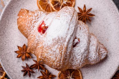 Koyu beton arka planda meyveli taze kruvasan.