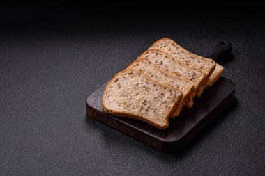 Koyu beton arka planda tahıllı ve tohumlu kahverengi ekmek