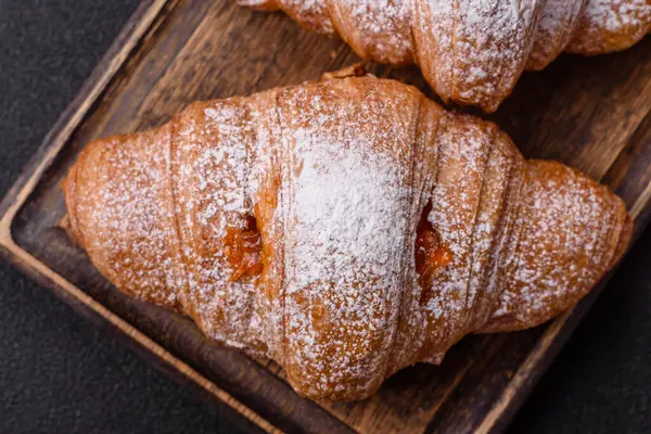 Koyu beton arka planda meyveli taze kruvasan.