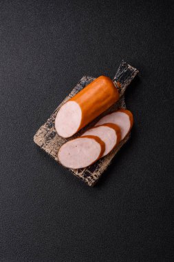 Lezzetli haşlanmış tavuk ya da koyu beton arka planda dilimlenmiş domuz sosisi.