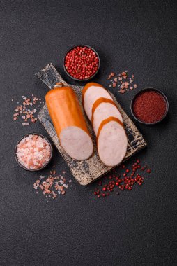 Lezzetli haşlanmış tavuk ya da koyu beton arka planda dilimlenmiş domuz sosisi.