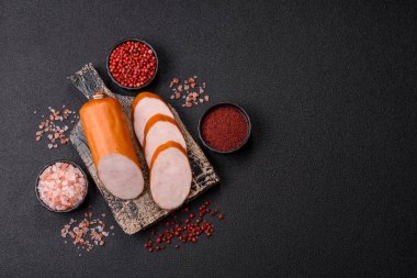 Lezzetli haşlanmış tavuk ya da koyu beton arka planda dilimlenmiş domuz sosisi.