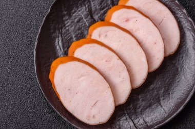 Lezzetli haşlanmış tavuk ya da koyu beton arka planda dilimlenmiş domuz sosisi.