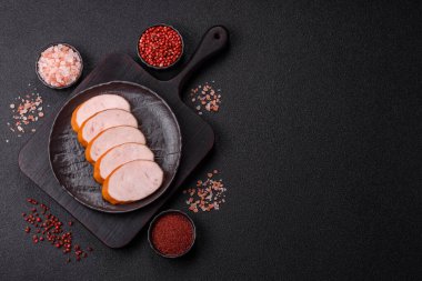 Lezzetli haşlanmış tavuk ya da koyu beton arka planda dilimlenmiş domuz sosisi.