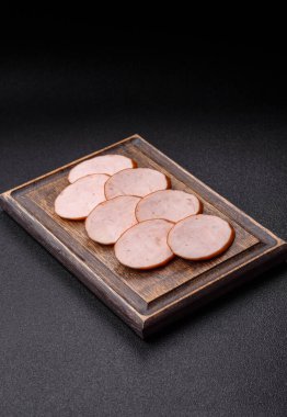 Lezzetli haşlanmış tavuk ya da koyu beton arka planda dilimlenmiş domuz sosisi.