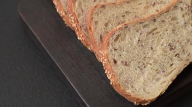 Koyu beton arka planda tahıllı ve tohumlu kahverengi ekmek