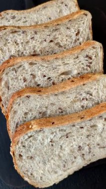 Koyu beton arka planda tahıllı ve tohumlu kahverengi ekmek