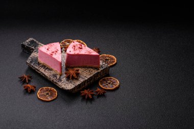 Ahududu ya da çilek aromalı, koyu beton arka planda maskaron peynirli tatlı bir cheesecake.