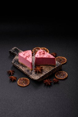 Ahududu ya da çilek aromalı, koyu beton arka planda maskaron peynirli tatlı bir cheesecake.