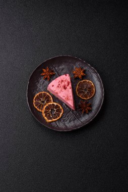 Ahududu ya da çilek aromalı, koyu beton arka planda maskaron peynirli tatlı bir cheesecake.