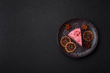 Ahududu ya da çilek aromalı, koyu beton arka planda maskaron peynirli tatlı bir cheesecake.