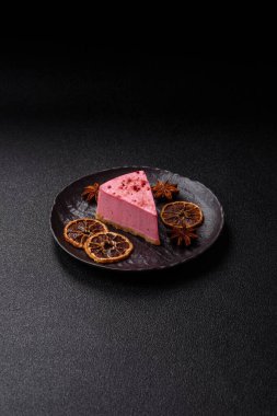 Ahududu ya da çilek aromalı, koyu beton arka planda maskaron peynirli tatlı bir cheesecake.