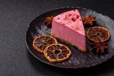 Ahududu ya da çilek aromalı, koyu beton arka planda maskaron peynirli tatlı bir cheesecake.